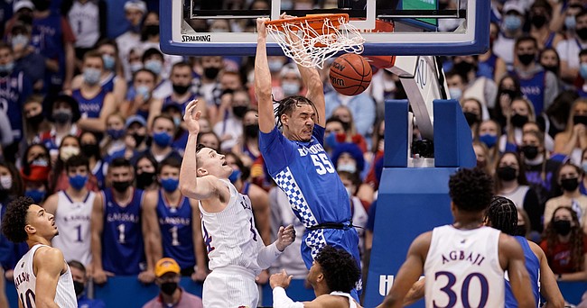 Kentucky forward Lance Ware (55) delivers a jam past Kansas forward Mitch Lightfoot (44) during the first half on Saturday, Jan. 29, 2022 at Allen Fieldhouse.