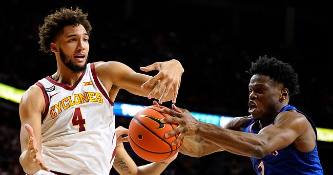 Kansas guard Joseph Yesufu (1) grabs a rebound in front of Iowa State forward George Conditt IV (4) during the second half of an NCAA college basketball game, Tuesday, Feb. 1, 2022, in Ames, Iowa. Kansas won 70-61. (AP Photo/Charlie Neibergall)