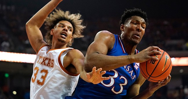 Kansas forward David McCormack grabs a rebound in front of Texas forward Tre Mitchell, left, during the first half of an NCAA college basketball game, Monday, Feb. 7, 2022, in Austin, Texas. (AP Photo/Eric Gay)