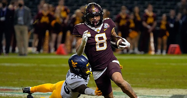 Minnesota running back Ky Thomas (8) gets away form West Virginia safety Saint McLeod during the second half of the Guaranteed Rate Bowl NCAA college football game Tuesday, Dec. 28, 2021, in Phoenix. Minnesota won 18-6.