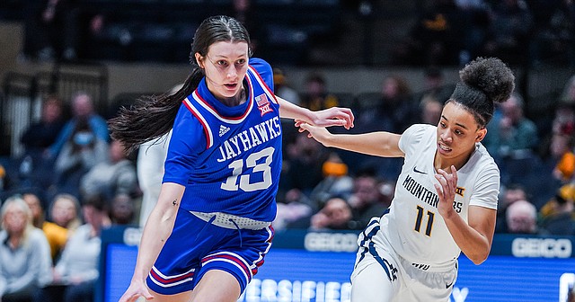 Kansas women's basketball junior guard Holly Kersgieter drives by West Virginia's JJ Quinerly during a game at WVU Coliseum in Morgantown, W.Va., on Feb. 9, 2022.