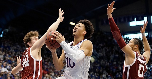 Kansas forward Jalen Wilson (10) elevates to the bucket between Oklahoma forward Jacob Groves (34) and Oklahoma guard Jordan Goldwire (0) during the second half on Saturday, Feb. 12, 2022 at Allen Fieldhouse.