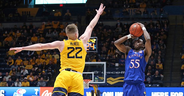 Kansas guard Jalen Coleman-Lands (55) shoots as West Virginia guard Sean McNeil (22) defends during the first half of an NCAA college basketball game in Morgantown, W.Va., Saturday, Feb. 19, 2022.