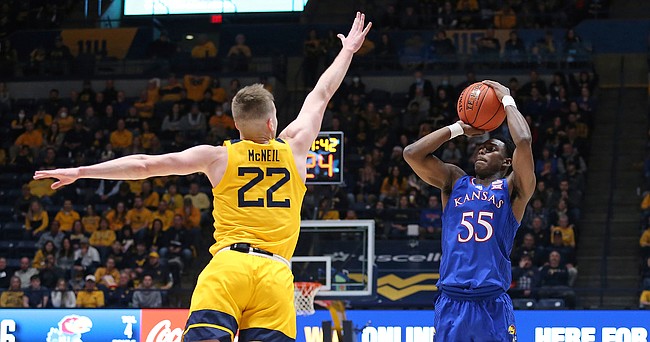 Kansas guard Jalen Coleman-Lands (55) shoots as West Virginia guard Sean McNeil (22) defends during the first half of an NCAA college basketball game in Morgantown, W.Va., Saturday, Feb. 19, 2022.