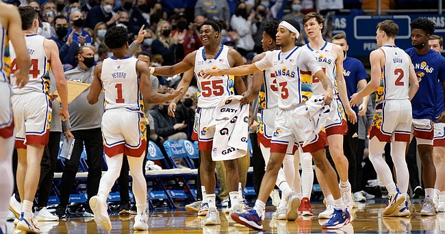 Kansas guard Jalen Coleman-Lands (55) comes in to celebrate with Kansas guard Joseph Yesufu (1) after a three by Yesufu during the first half on Tuesday, Feb. 22, 2022 at Allen Fieldhouse.