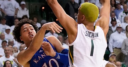 Kansas forward Jalen Wilson (10) passes the ball over Baylor forward Jeremy Sochan (1) during the first half of an NCAA college basketball game Saturday, Feb. 26, 2022, in Waco, Texas.