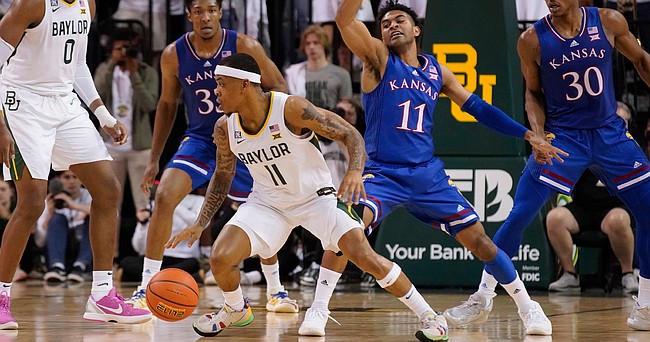 Baylor guard James Akinjo (11) reverses his dribble on Kansas guard Remy Martin (11) during the first half of an NCAA college basketball game Saturday, Feb. 26, 2022, in Waco, Texas.