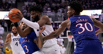 Kansas guard Dajuan Harris Jr. (3) and and guard Ochai Agbaji (30) defend against a drive to the basket by TCU guard Mike Miles (1) in the second half of an NCAA college basketball game in Fort Worth, Texas, Tuesday, March 1, 2022. (AP Photo/Tony Gutierrez)