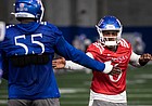 Kansas junior quarterback Jalon Daniels high fives his teammate during spring practice at the indoor practice facility on Tuesday, March 1, 2022.