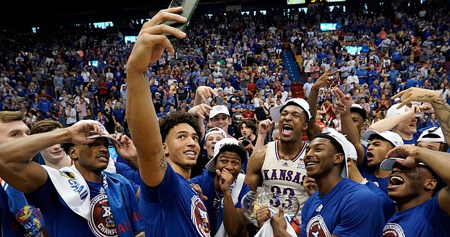 Kansas forward Jalen Wilson puts up his phone to get a photo of his teammates following the Jayhawk's 70-63, overtime win against against the Texas.
