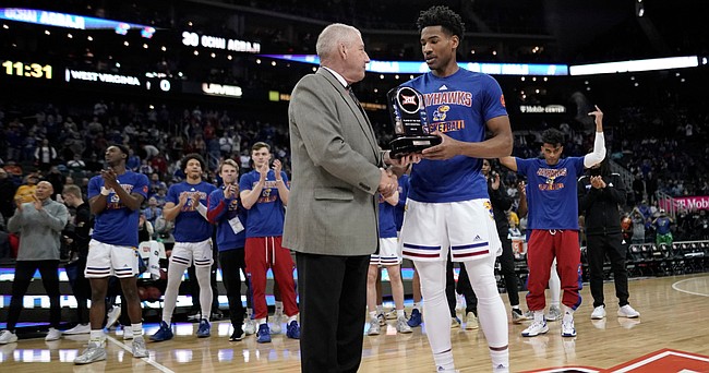 Kansas guard Ochai Agbaji receives the Big 12 Player of the Year trophy from commissioner Bob Bowlsby prior to tipoff against West Virginia on Thursday, March 10, 2022 at T-Mobile Center in Kansas City.