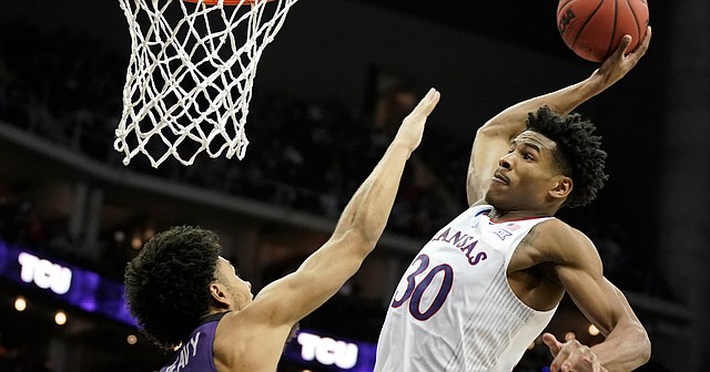 Kansas guard Ochai Agbaji (30) brings down a thunderous dunk over TCU guard Micah Peavy (0) during the second half on Friday, March 11, 2022 at T-Mobile Center in Kansas City.
