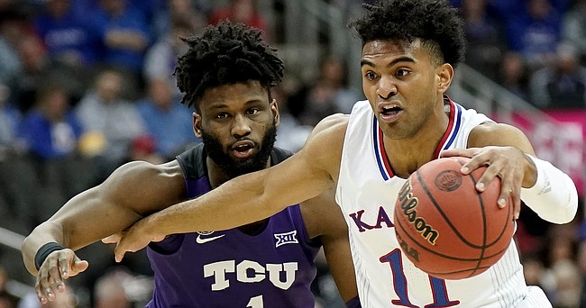 Kansas guard Remy Martin (11) drives against TCU guard Mike Miles (1) during the first half on Friday, March 11, 2022 at T-Mobile Center in Kansas City.