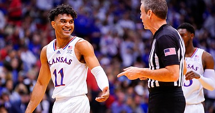 Kansas guard Remy Martin (11) smiles as he chats with an official during the first half on Saturday, Dec. 11, 2021, at Allen Fieldhouse.