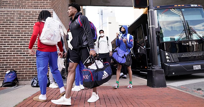 Kansas guard Ochai Agbaji and other players grab their as the team unloads from the bus upon the Jayhawks' arrival at their hotel in downtown Fort Worth, Texas, on Tuesday, March 15, 2022.