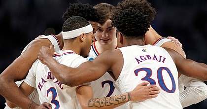 The Jayhawks come together in a huddle during the first half on Saturday, March 19, 2022 at Dickies Arena in Fort Worth, Texas.