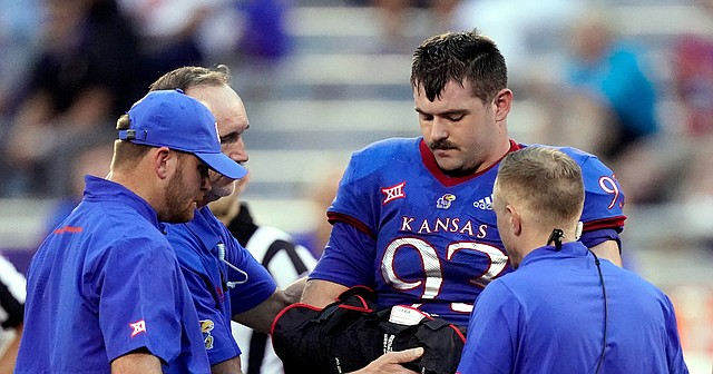 Kansas defensive lineman Sam Burt (93) is helped off the field after an injury during the first half of an NCAA college football game against South Dakota Friday, Sept. 3, 2021, in Lawrence, Kan. (AP Photo/Charlie Riedel)