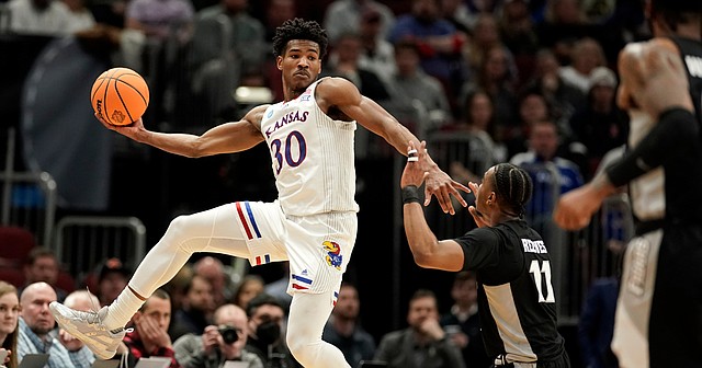 Kansas guard Ochai Agbaji (30) leaps to save a ball before Providence guard A.J. Reeves (11) during the first half on Friday, March 25, 2022 at United Center in Chicago.