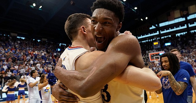 Kansas forward David McCormack (33) wraps his arms around fellow senior Mitch Lightfoot (44) following the Jayhawks' 70-63, overtime win against Texas on Saturday, March 5, 2022 at Allen Fieldhouse. The Jayhawks defeated the Longhorns to win a share of the Big 12 conference title.