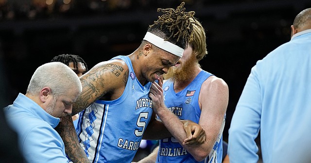 North Carolina forward Armando Bacot is helped off the court during the second half of a game against Duke in the Men's Final Four on April 2, 2022, in New Orleans.