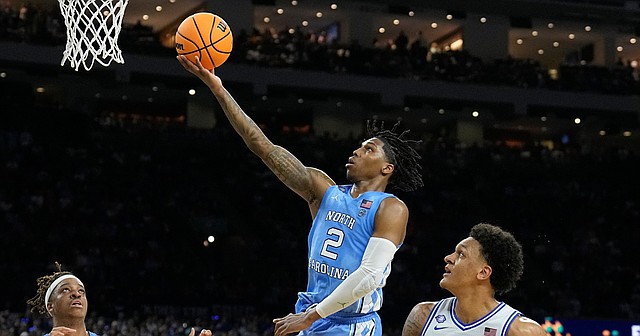 North Carolina's Caleb Love (2) scores ahead of Duke's Paolo Banchero (5) during the second half of a college basketball game in the semifinal round of the Men's Final Four NCAA tournament, Saturday, April 2, 2022, in New Orleans.