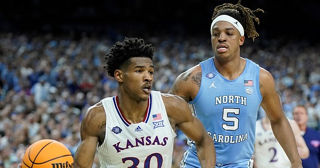 Kansas guard Ochai Agbaji (30) goes baseline past North Carolina forward Armando Bacot (5) during the second half of the NCAA National Championship game on Monday, April 4, 2022 at Caesars Superdome in New Orleans.