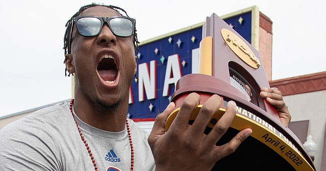 David McCormack holds the NCAA National Championship trophy and yells to the crowd during a parade Sunday, April 10, 2022, to celebrate the KU men’s basketball team winning the NCAA basketball championship.
