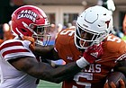 Texas' Bijan Robinson is hit by Louisiana's Lorenzo McCaskill during the second half of game on Sept. 4, 2021, in Austin, Texas.