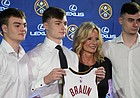 Denver Nuggets guard Christian Braun, second from left, holds up his jersey for a photo with his brothers Parker, left, and Landon, right, and mother, Lisa, after being introduced to the media during a news conference on June 27, 2022, in Denver.