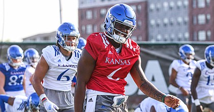 Kansas junior quarterback Jalon Daniels (6) laughs while stretching during the first day of practice on Tuesday, Aug. 2, 2022.