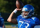 Kansas redshirt sophomore offensive lineman Deondre Doiron throws a football during a training camp practice on Aug. 12, 2022. Doiron, who joined the Jayhawks over the summer, played right tackle at Buffalo but has been playing center as he settles in with the Jayhawks.