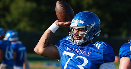 Kansas redshirt sophomore offensive lineman Deondre Doiron throws a football during a training camp practice on Aug. 12, 2022. Doiron, who joined the Jayhawks over the summer, played right tackle at Buffalo but has been playing center as he settles in with the Jayhawks.