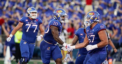 Kansas running back Daniel Hishaw Jr. (20) slaps hands with Kansas offensive lineman Dominick Puni (67) after a touchdown by Hishaw during the first quarter on Friday, Sept. 2, 2022 at Memorial Stadium.