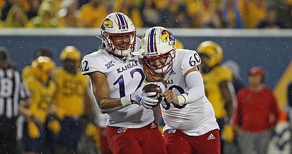 Kansas running back Torry Locklin, left, and long snapper Luke Hosford celebrate after Locklin recovered a fumble following a muffed punt return during a game against West Virginia in Morgantown, W.Va., on Sept. 10, 2022.