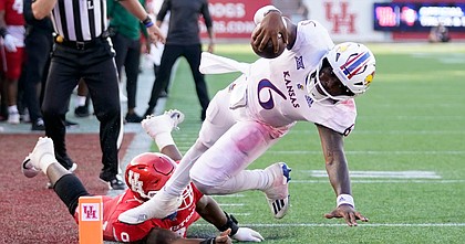 Kansas quarterback Jalon Daniels (6) leaps into the end zone for a touchdown past Houston defensive lineman Nelson Ceaser during the second half of an NCAA college football game, Saturday, Sept. 17, 2022, in Houston. (AP Photo/Eric Christian Smith)