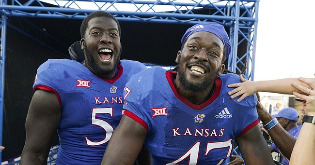 Kansas offensive lineman Ar'maj Reed-Adams, left, and defensive end Lonnie Phelps celebrate as they leave the field following the Jayhawks' 14-11 win over Iowa State to remain unbeaten on Saturday, Oct. 1, 2022 at Memorial Stadium.