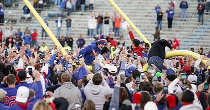 The south upright comes down as Kansas fans celebrate following the Jayhawks' 37-16 win over the Cowboys on Saturday at Memorial Stadium.