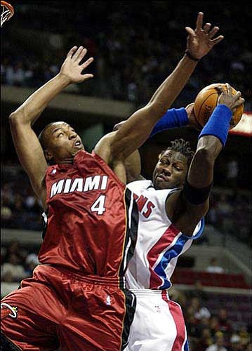 Detroit's Ben Wallace, right, grabs a first-quarter rebound from
Miami's Caron Butler. The Pistons beat the Heat, 93-62, Monday in
Auburn Hills, Mich.
