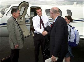 Kansas University interim athletic director Drue Jennings, left, looks on as KU Chancellor Robert Hemenway, second from right, greets Illinois basketball coach Bill Self, center, who arrived with his family, including daughter Lauren, right, at Lawrence Municipal Airport. Though Hemenway and Jennings declined comment on
the matter Sunday when Self arrived, a news conference has been scheduled today to introduce Self as the next Kansas men's basketball coach.

