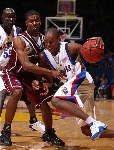 Kansas University freshman Russell Robinson, right, drives against
Texas A&amp;M's Dominique Kirk during a game Jan. 5 at Allen
Fieldhouse. Robinson and fellow backup point guard Jeff Hawkins are
battling for the right to be No. 2 off the bench behind senior
Aaron Miles.
