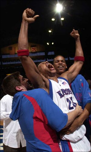 Flanked by Stephen Vinson, left, and C.J. Giles, Kansas
University's Wayne Simien celebrates the Jayhawks' 81-79 victory
over Oklahoma State. Simien scored a career-high 32 points in the
Jayhawks' victory Sunday in Allen Fieldhouse.
