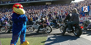 Baby Jay watches as Kansas State fans roll by on their Harley-Davidson motorcycles Saturday for Harley Day at the KSU Stadium.