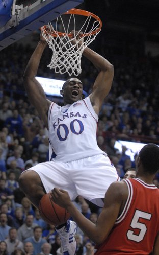 Kansas' Darrell Arthur hangs on the rim after an accidental alley-oop from teammate Mario Chalmers against Texas Tech on Monday at Allen Fieldhouse.