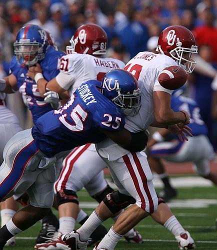Kansas safety Darrell Stuckey forces Oklahoma quarterback Landry Jones to fumble during the second quarter. The ball was returned to the Sooners because of a penalty.