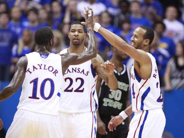 Kansas teammates Tyshawn Taylor, Marcus Morris (22) and Travis Releford come together for high fives during the second half Friday, Nov 19, 2010 at Allen Fieldhouse.