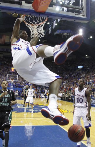 Kansas forward Marcus Morris swings off the rim after delivering a dunk against North Texas during the second half Friday, Nov 19, 2010 at Allen Fieldhouse.