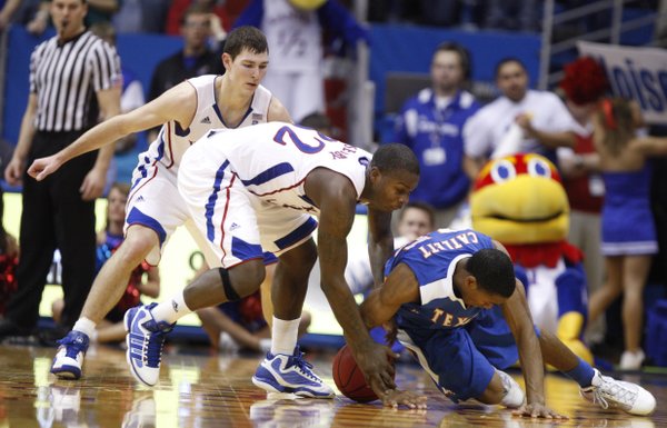 Kansas guard Josh Selby gets tied up with UT Arlington guard Cameron Catlett during the second half, Wednesday, Dec. 29, 2010 at Allen Fieldhouse. In back is Kansas guard Tyrel Reed.