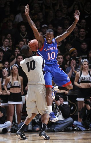 Kansas guard Tyshawn Taylor fouls Colorado guard Alec Burks (10) during the first half of an NCAA college basketball game Tuesday, Jan. 25, 2011, in Boulder, Colo.
