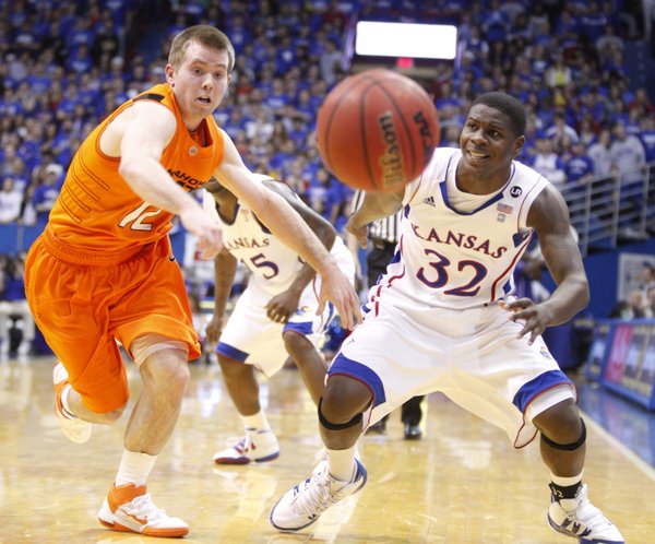 Oklahoma State guard Keiton Page knocks the ball away from Kansas guard Josh Selby during the first half on Monday, Feb. 21, 2011 at Allen Fieldhouse.
