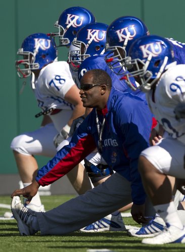 Kansas head coach Turner Gill stretches out with his players during practice on Monday, April 11, 2011 at the practice fields near Memorial Stadium.